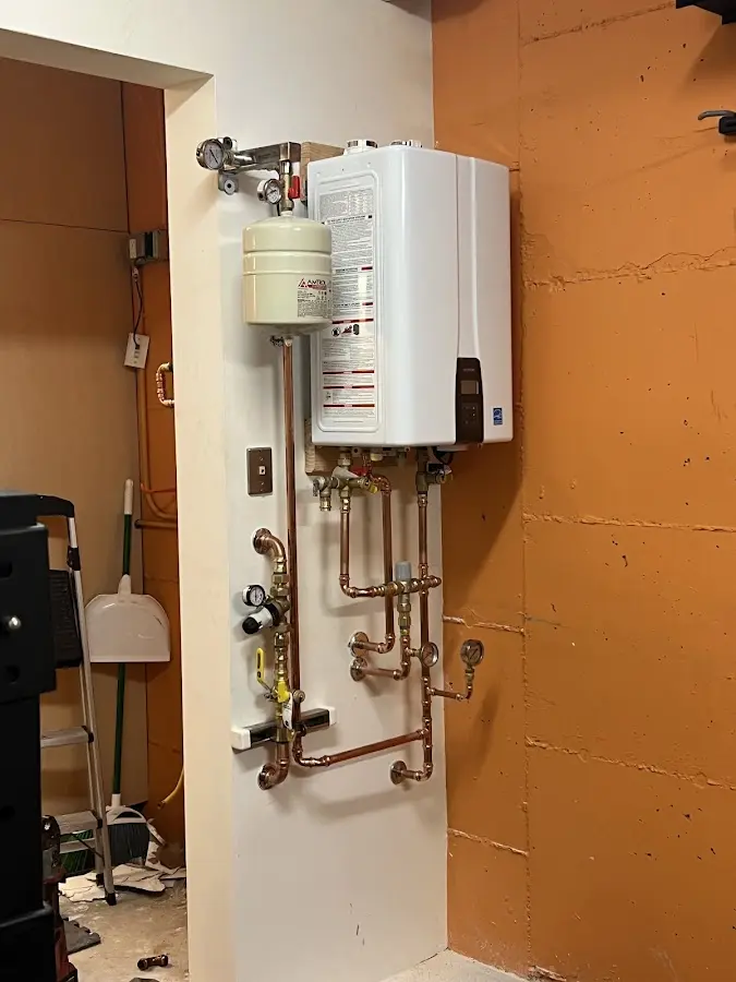 Plumbing technician inspecting water heater connections in Porter